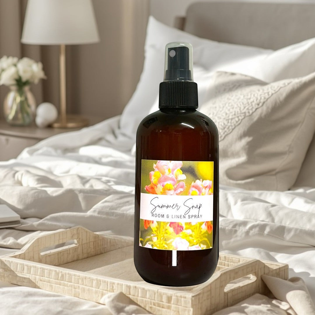 Summer Snap Room & Linen Spray with floral and fruit notes in amber bottle.