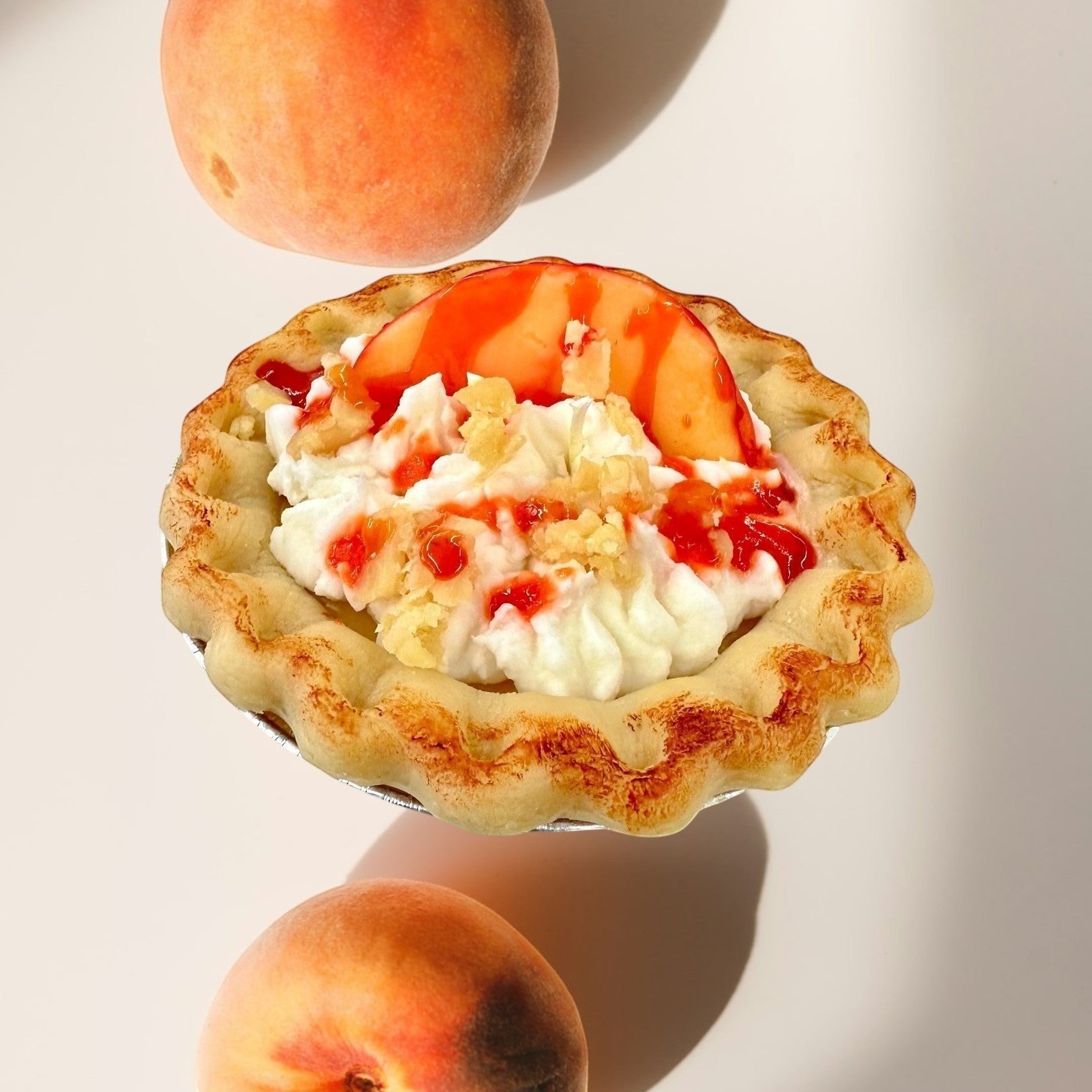 Peach Pie candle designed to look like a real pie with whipped cream and fruit topping.