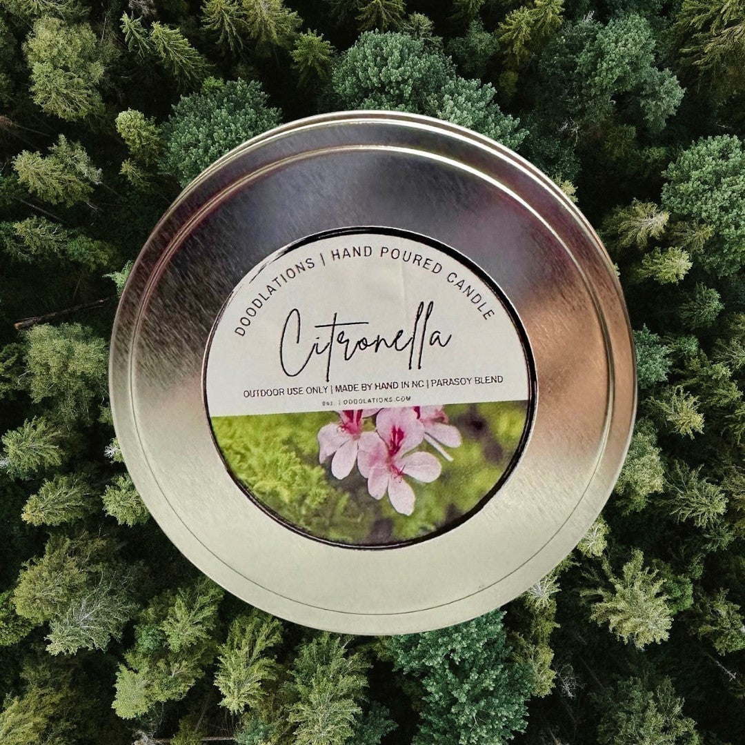 Doodlations Citronella outdoor candle in a metal tin with pink flowers and greenery. Hand-poured luxury home fragrance.